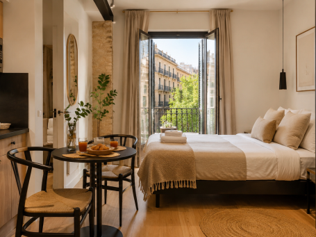 Estudio turístico con dormitorio, mesa y balcón